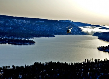 Helicopter flying over foggy mountain lake